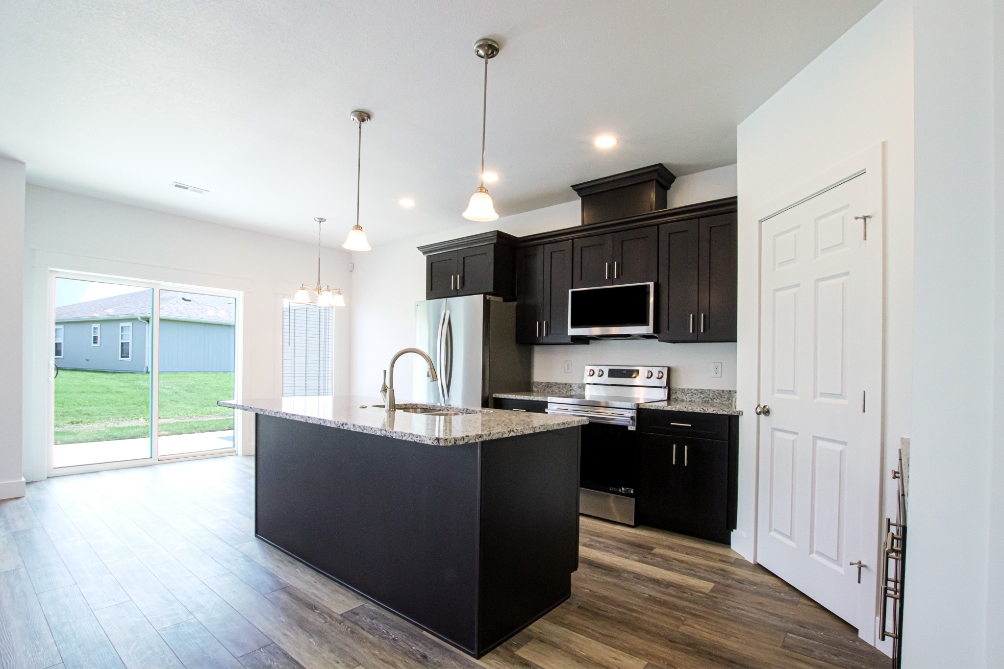 Finished SAAK Builders kitchen with dark cabinetry and granite island