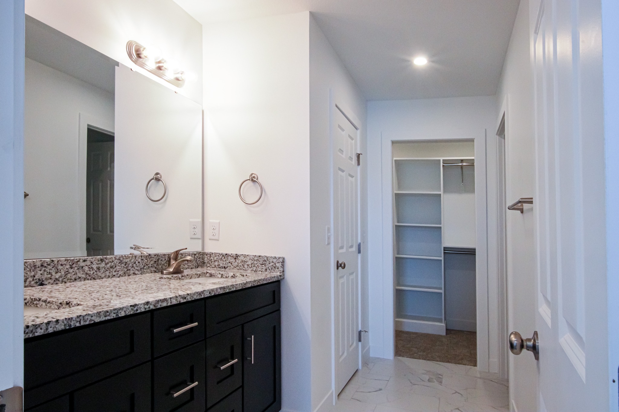 Custom home primary bathroom vanity and walk-in closet